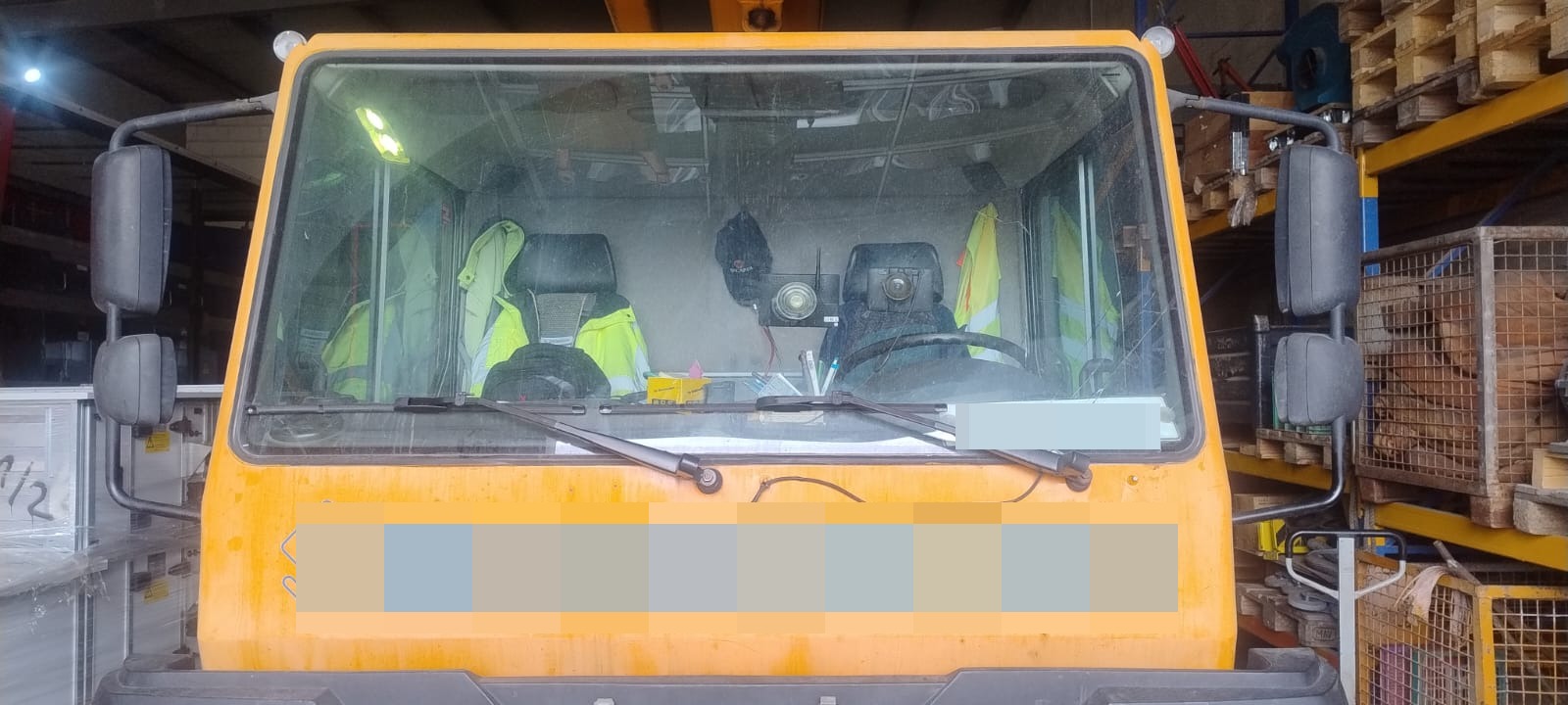 Baumaschine mit alter Frontscheibe im Fahrerhaus